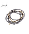 Grijze armband met glaskralen en goudkleurige accenten